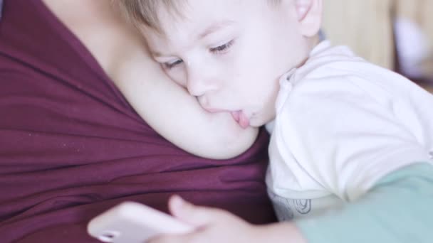 Мальчик ест молоко из женской груди — стоковое видео