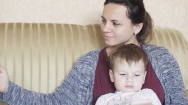 Annesiyle kanepede yatan çocuk.