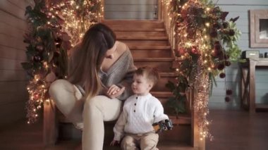 Anne ve oğlu bir tahtanın üzerinde oturuyor.