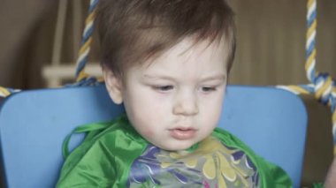 Çocuk masaya sümük siliyor.