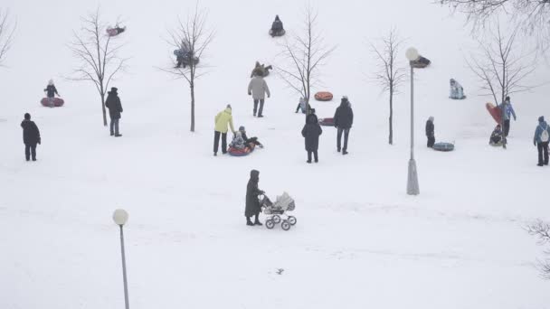 Rodzice z dziećmi zjeżdżają ze wzgórza — Wideo stockowe