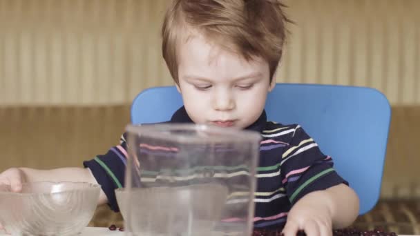 Boy child is playing beans — Stock Video