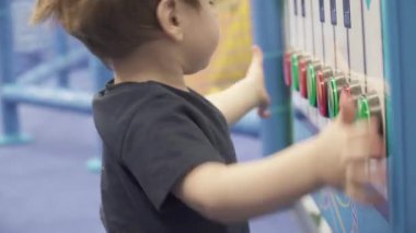 Çocuk bir müzikalin tuşlarına basıyor