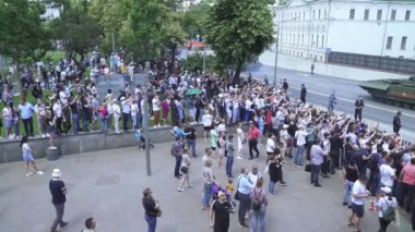 İzleyiciler ve askeri teçhizat geçit töreninden geliyor.