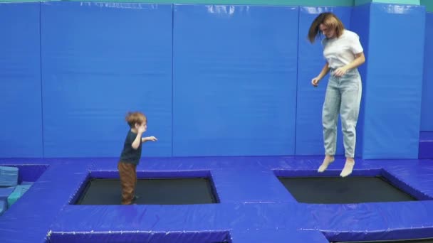 Mom with son on a trampoline — Stock Video