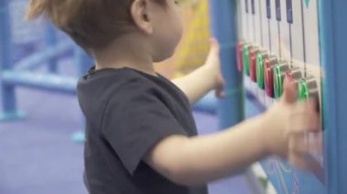 Çocuk bir müzikalin tuşlarına basıyor