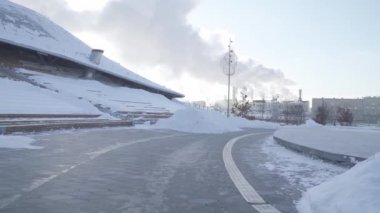 Zaryadye parkındaki temiz yollar ve kar yığınları ve Raushskaya enerji santralinin manzarası