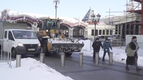 Snö borttagning av arbetare och en traktor på Manezhnaya Square efter ett tungt snöfall — Stockvideo
