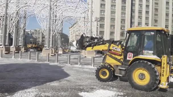 Retiro de nieve por los trabajadores y un tractor en la plaza Manezhnaya después de una fuerte nevada — Vídeos de Stock