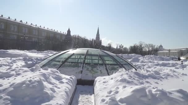 Schneebedeckte Kuppeln des Einkaufszentrums Okhotny Ryad und von der Seite des Alexandergartens vom Schnee befreite Fußgängerwege mit Blick auf den Kreml — Stockvideo