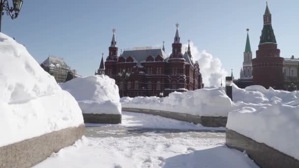 Snö-täckta kupoler i Okhotny Ryad köpcentrum och gågator rensas av snö med utsikt över Kreml från sidan av Alexander Garden — Stockvideo