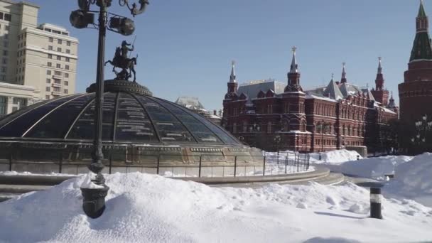 Schneebedeckte Kuppeln des Einkaufszentrums Okhotny Ryad und von der Seite des Alexandergartens vom Schnee befreite Fußgängerwege mit Blick auf den Kreml — Stockvideo