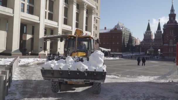 Snö borttagning av arbetare och en traktor på Manezhnaya Square efter ett tungt snöfall — Stockvideo