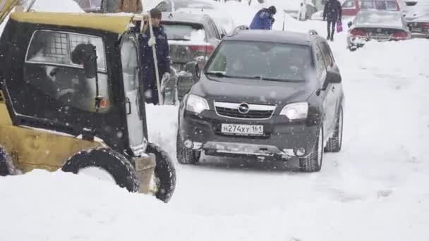 Het werk van een sneeuwschuiver trekker om sneeuw te verwijderen in een woonwijk van de stad Moskou Yuzhnoye Butovo — Stockvideo