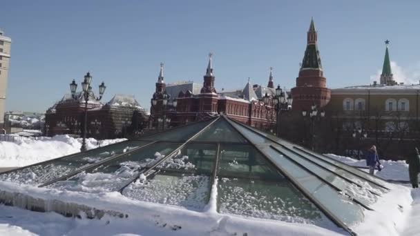 Domos cubiertos de nieve del centro comercial Okhotny Ryad y caminos peatonales despejados de nieve con vistas al Kremlin desde el lado del Alexander Garden — Vídeos de Stock