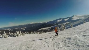 Kar dağlarından kayak yapan kadın.