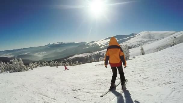 Kvinna nedstigning på skidor från snöbergen — Stockvideo