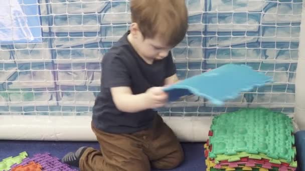 Gyermek hajtogatja ortopéd szőnyeg a parkban — Stock videók