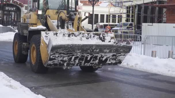 Sneeuw verwijderen door werknemers en een tractor op Manezhnaya Square na een zware sneeuwval — Stockvideo