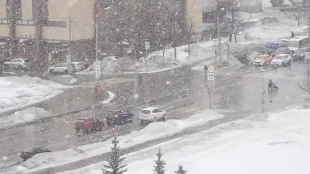 Grote sneeuw op de achtergrond van een drukke kruising van Gorchakov Street en Akademik Lazarev Street in Moskou — Stockvideo