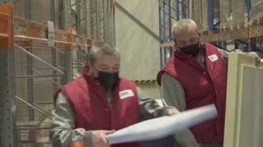 Kovivak 'ın deposundaki bir lojistik şirketinin çalışanı tarafından Kovivak' la birlikte kutuların istiflenmesi.