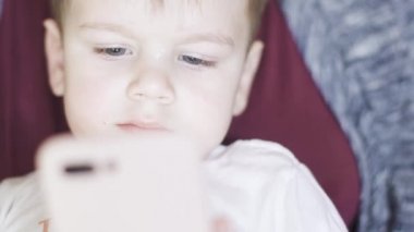 Çocuk annesinin kollarında oturuyor.