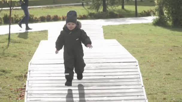 Menino correndo em plataformas de salto de madeira no parque da cidade — Vídeo de Stock
