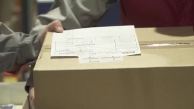 Kovivak 'ın deposundaki bir lojistik şirketinin çalışanı tarafından Kovivak' la birlikte kutuların istiflenmesi.