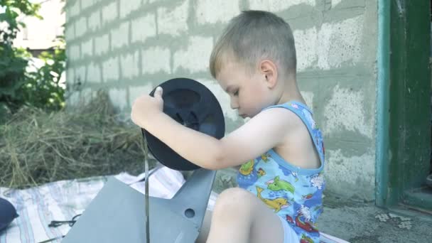 Een jongen speelt met een grijze magnetische babina — Stockvideo