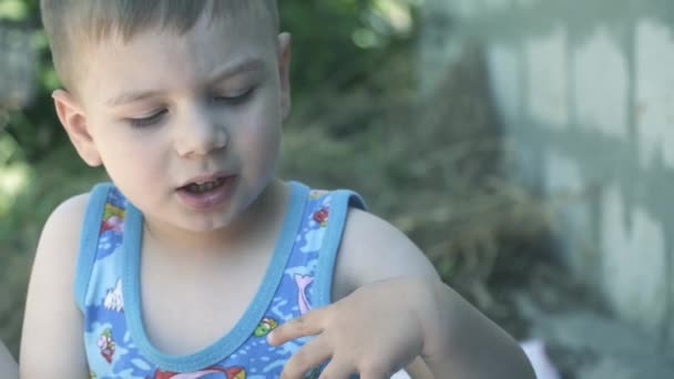 Un niño juega con un plástico blanco — Vídeos de Stock