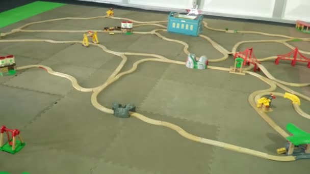 Los niños juegan un gran ferrocarril de juguete en el pabellón interior — Vídeo de stock