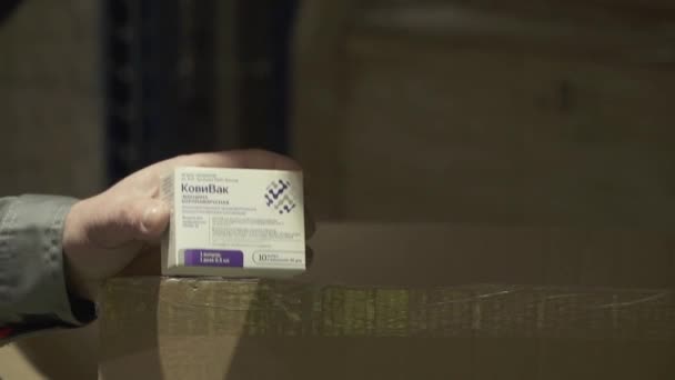 Impfstoffverpackungen von Kovivac in den Händen eines Mitarbeiters eines Logistikunternehmens im Lager von Kovivac — Stockvideo