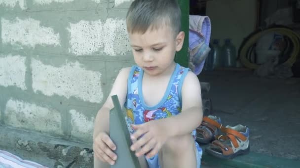 Ein Junge spielt mit einer grauen Magnetbabina — Stockvideo