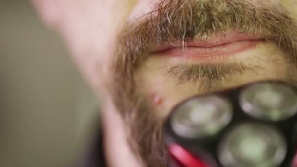 El hombre se afeita la barba con afeitadora eléctrica — Vídeos de Stock