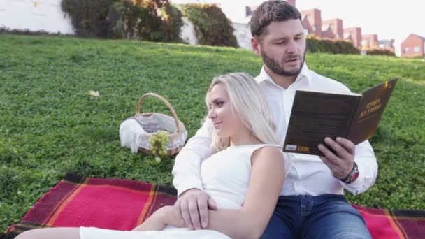 Casal no gramado livro de leitura — Vídeo de Stock