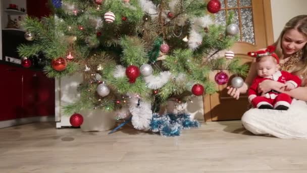 Mutter mit Baby in der Nähe des Weihnachtsbaums — Stockvideo
