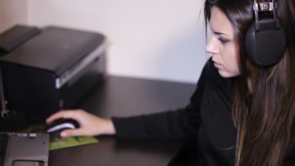 Girl with headphones at table — Stock Video