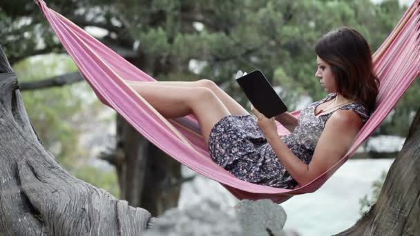 在吊床上电子书的女人 — 图库视频影像
