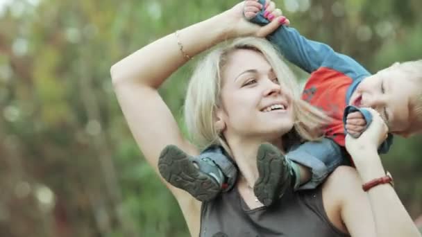 El hijo sobre los hombros a la mamá — Vídeo de stock