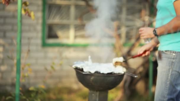 Mężczyzna gotuje mięso na grilla — Wideo stockowe