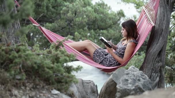 Mädchen in der Hängematte E-Book-Lesen — Stockvideo