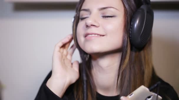 Дівчина в навушниках посміхається — стокове відео