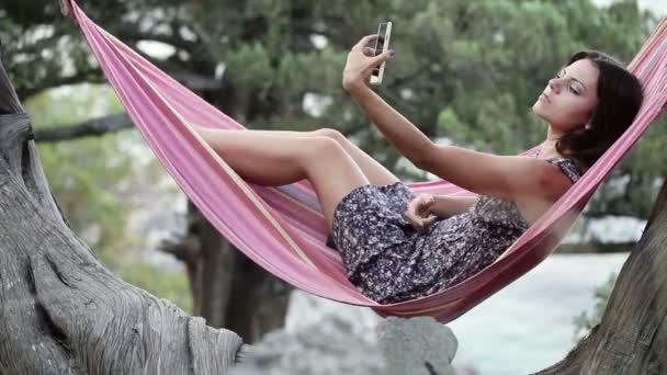 在吊床上智能手机的女孩自我 — 图库视频影像
