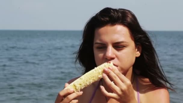 Девочка ест кукурузу — стоковое видео