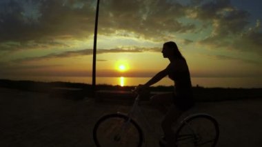 Gün batımında bisikletli kız