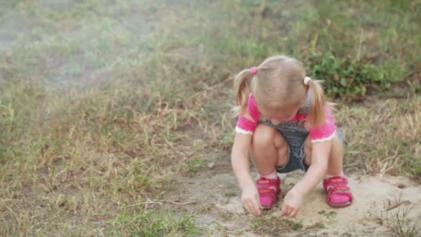 Маленькая девочка в песочнице — стоковое видео