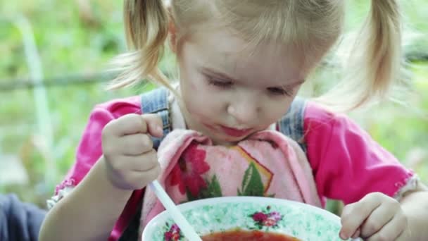 Dziewczynka jedzenie z łyżeczką — Wideo stockowe