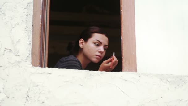 Κορίτσι στο παράθυρο κάνει μακιγιάζ — Αρχείο Βίντεο