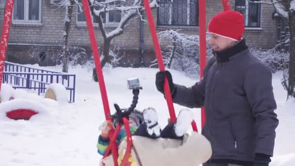 Kind im Winter auf Schaukel — Stockvideo