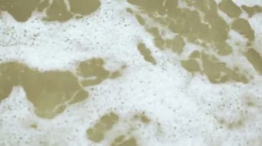 Çakıl taşları ve denizde sörf